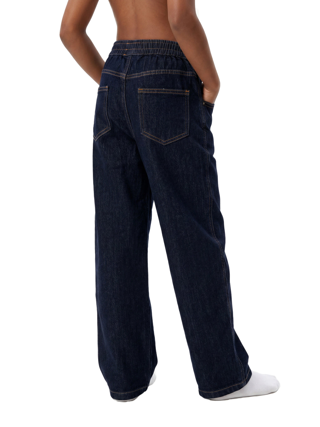 Rear view of a person wearing dark indigo wide-leg jeans with an elastic waistband and back pockets, standing against a plain white background.