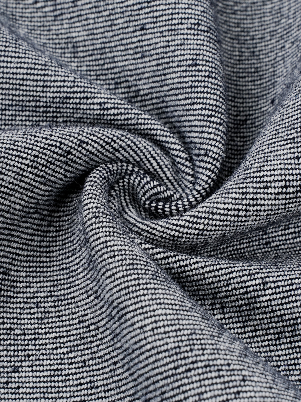 A close-up of a textured woven fabric with a fine ribbed pattern in dark gray and white, arranged in a spiral drape.
