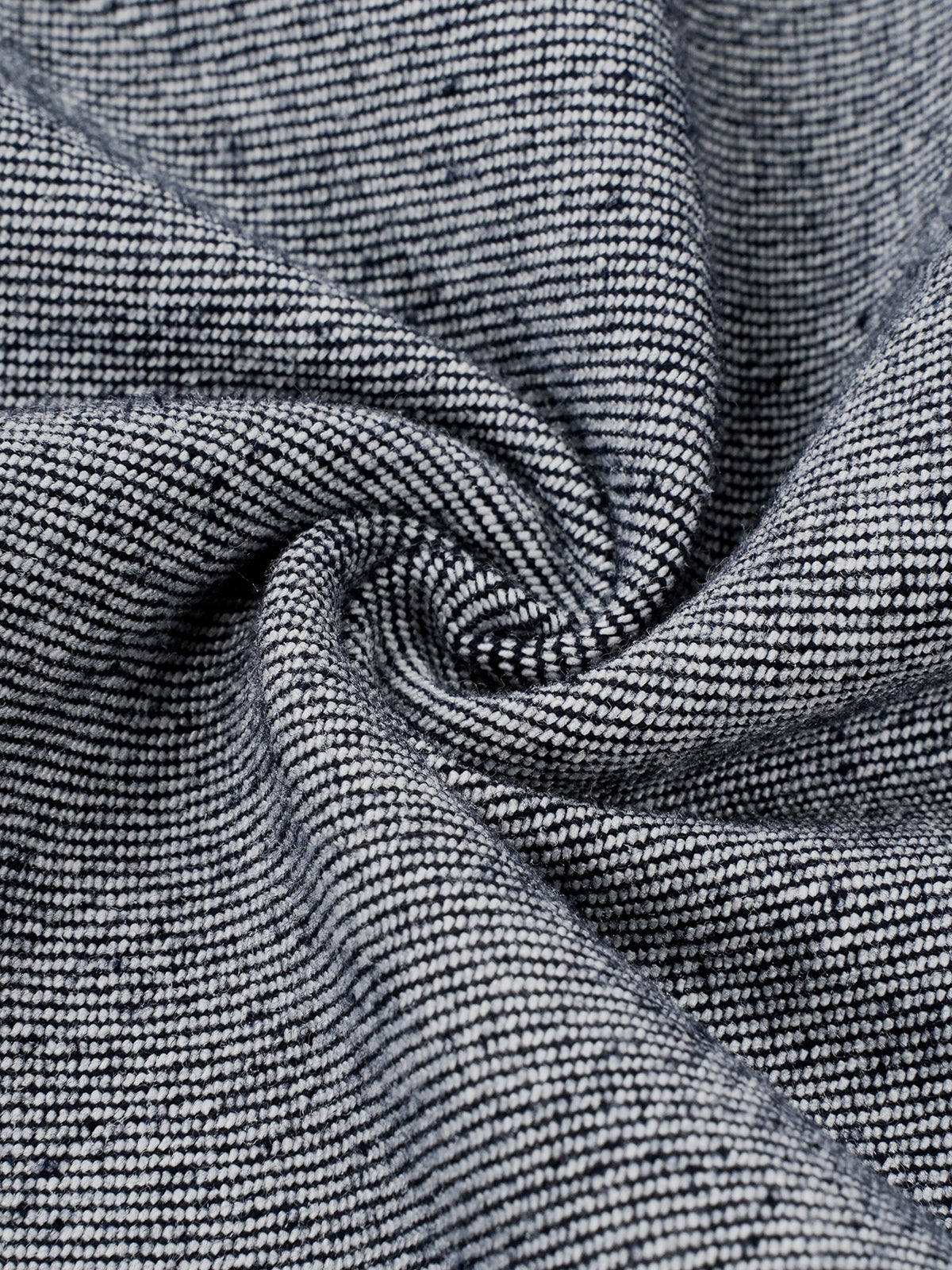 A close-up of a textured woven fabric with a fine ribbed pattern in dark gray and white, arranged in a spiral drape.