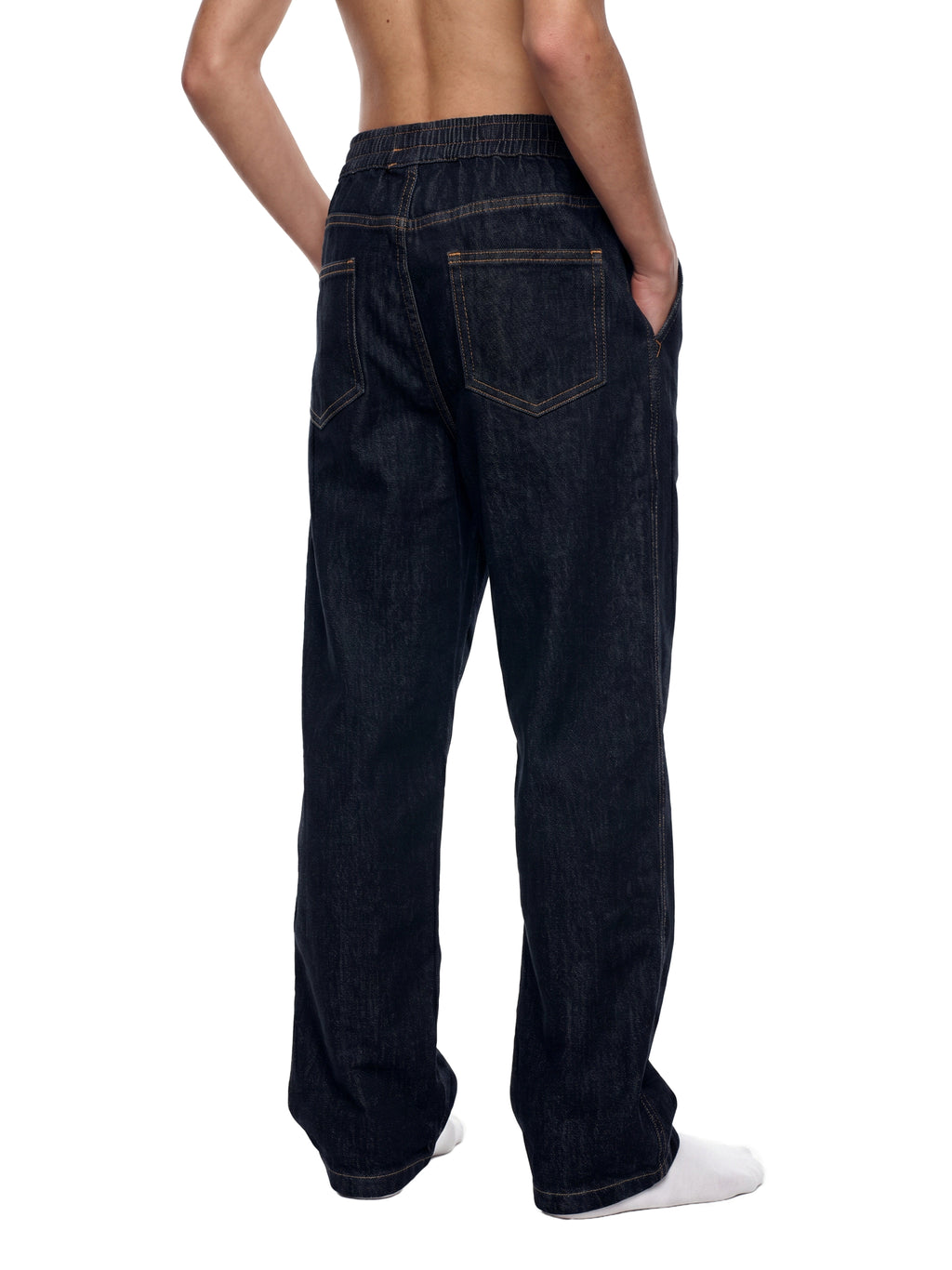 Rear view of a person wearing dark indigo denim jeans with a relaxed straight-leg fit, shown against a plain white background.